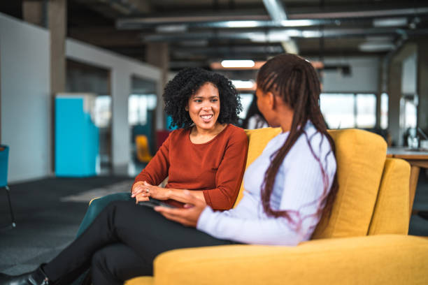 istock Central American Female Crypto Handlers Talking While Sitting on Office Sofa 1459274395