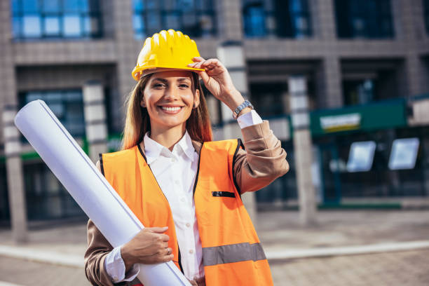 istock Engineer woman in safety equipment  holding plans. Building, developing, construction and architecture concept. 1459275097