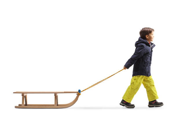 istock Full length profile shot of a boy pulling a wooden sleigh 1459275547