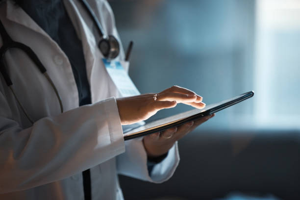 Telehealth, digital tablet and doctor hands for hospital innovation, software management and results update in dark workplace. Healthcare, cardiology and telecom medical professional with technology telesalud, tableta digital y manos del médico para la innovación hospitalaria, la gestión de software y la actualización de resultados en el lugar de trabajo oscuro. profesional médico de la salud, cardiología y telecomunicaciones con tecnología