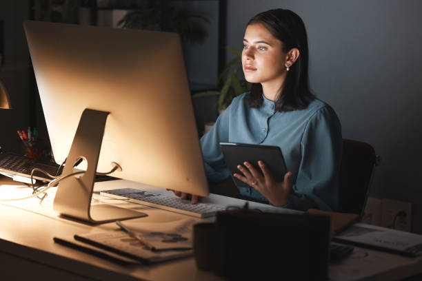 Night office, computer and business woman with tablet for digital marketing, seo analytics and multimedia application review. Website design, graphic designer and creative employee in dark workspace