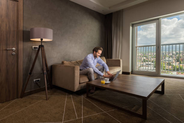 istock Happy male entrepreneur working on a computer in a hotel room. 1459279843
