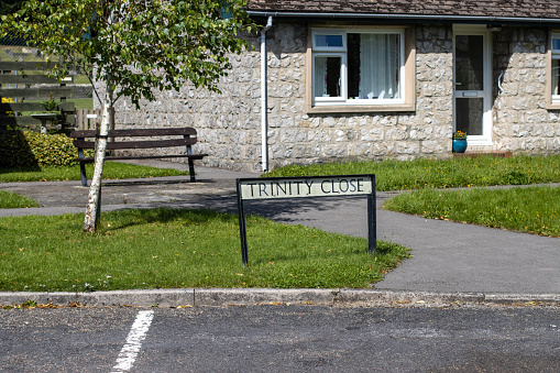 Trinity Close at Ashford-in-the-Water in Peak District National Park at Derbyshire, England, with a bungalow in the background.