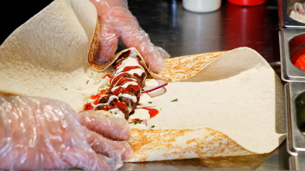 istock Chef cooking lula kebab in turkish restaurant. Cook rolling kebab and minced meat wrapping in pita lavash close up 1459280407