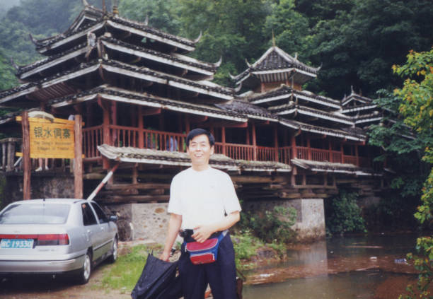 Woman in red hanfu dress with white umbrella on ancient stepped fortress wall, temple complex visible background, daytime portrait