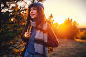 Woman admiring the nature, while hiking in the forest during sunset