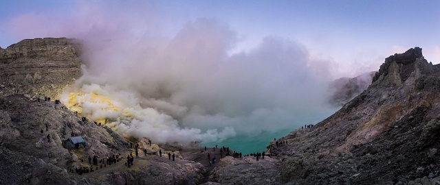 A panoramic scenery of the volcanic eruption smoke above the small lake