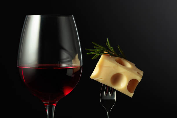 Glass of red wine and Maasdam cheese with rosemary. stock photo