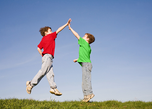 Two Boys Giving a High Five in the Sky