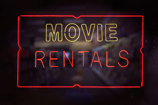 Neon Movie Rentals Sign in Rainy Window