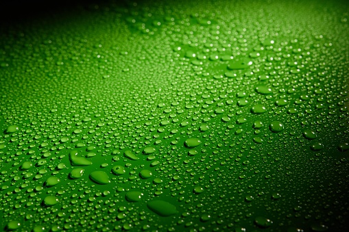 A closeup shot of waterdrops on a green surface