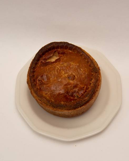 istock Vertical close up traditional British pork pie on white plate 1459296324