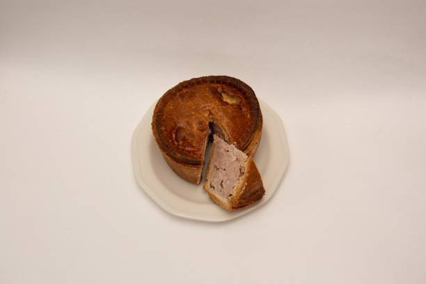istock Cut slice nestled in pork pie on white plate 1459296328