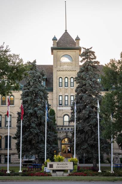 foto vertical del letrero y las banderas de la universidad de brandon en brandon, manitoba, canadá - university of manitoba fotografías e imágenes de stock
