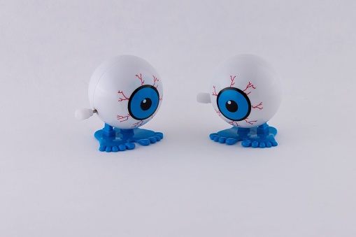 Two mechanical clattering blue eyeball toys isolated on a white background