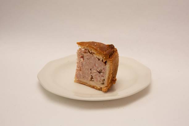 istock Tasty British crusty pork pie slice on a plate isolated on a white background 1459297223