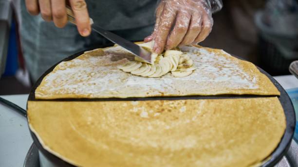 istock Making delicious crepes on a grill with fruit 1459300384