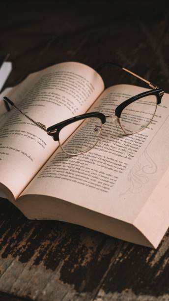 istock Closeup of glasses on open book 1459301574