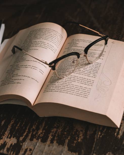 istock Closeup of glasses on open book 1459301575