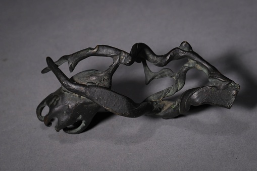 A black sculpture depicting a branch on a gray background in China