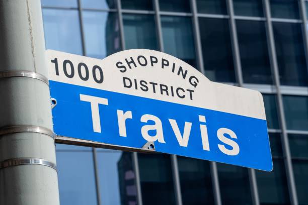 straßenschild "travis" in der innenstadt von houston, texas - travis county stock-fotos und bilder