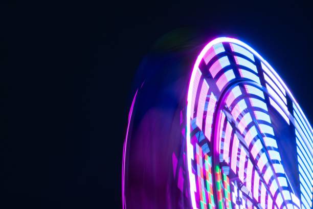 夜に照らされた観覧車の長時間露光ショット - ferris wheel wheel blurred motion amusement park ストックフォトと画像