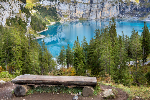 Amazing tourquise Oeschinnensee lake, wooden bench and Swiss Alps, Berner Oberland, Switzerland.