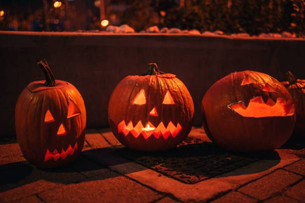 istock Carved Halloween pumpkins on the ground at night. 1459307754