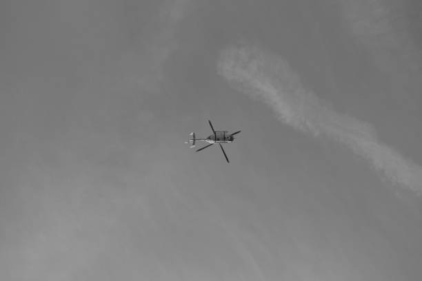 istock Grayscale low angle shot of a flying helicopter 1459308027