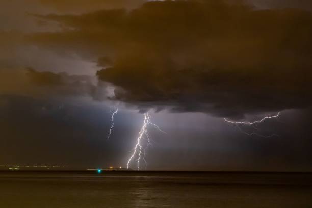 istock Lightning in a stormy night sky over a seascape hiding behind the clouds 1459308274