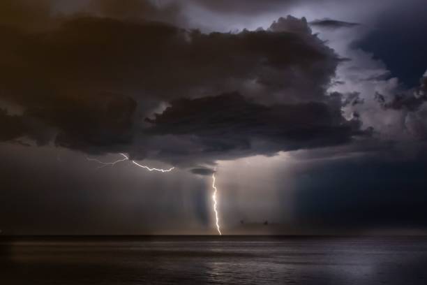 istock Lightning in a stormy night sky over a seascape hiding behind the clouds 1459308278