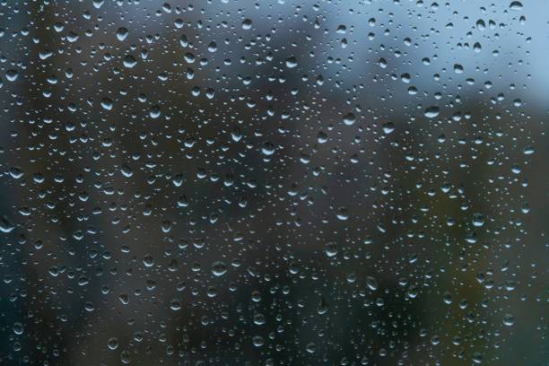 istock Raindrops on window glass on dark blue blurred background. Autumn rainy weather. Textured surface. 1459308363