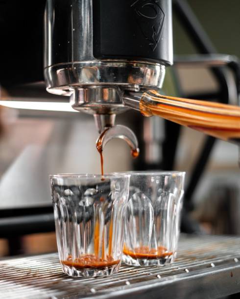 istock Vertical shot of coffee dripping from the machine into glass cups 1459308750
