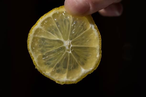 istock Closeup of a hand holding a lemon slice 1459308891