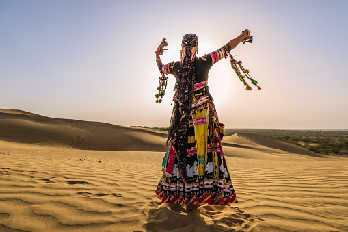 Indian woman from Kalbelia tribe dancing on a sand dune, Thar Desert, Rajasthan, India