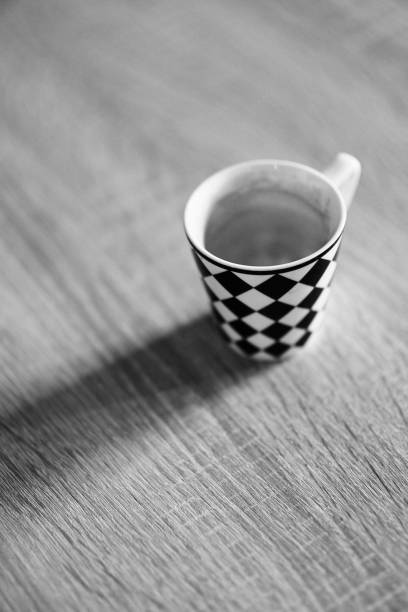 istock Vertical grayscale closeup of a checkered cup on the table. 1459309402