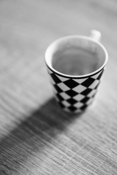 istock Vertical grayscale closeup of a checkered cup on the table. 1459309405