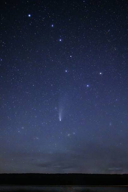 istock Vertical shot of a starry blue night sky with a shooting star 1459309466
