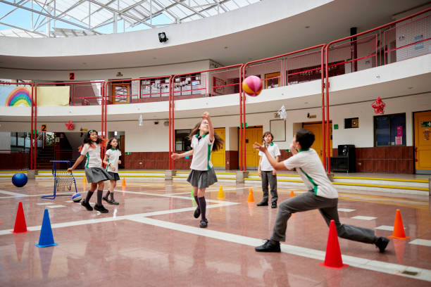 学校でボール遊びをする思春期前の男の子と女の子 - recreational equipment ストックフォトと画像