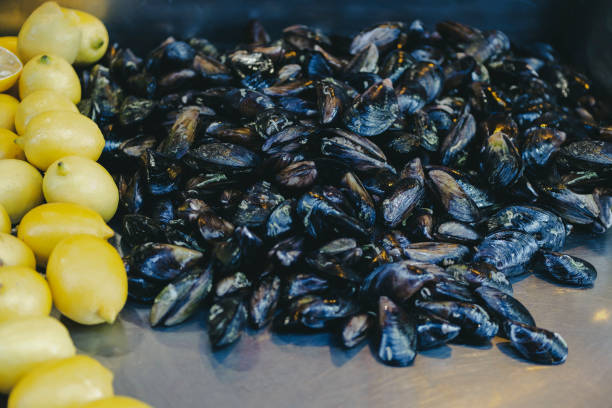 Turkish style appetizer street food stuffed mussels called midye dolma on bench for sale with lemon.