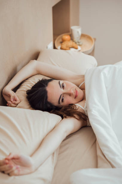 istock Serene woman stretching arms after good sleep on bed 1459314611
