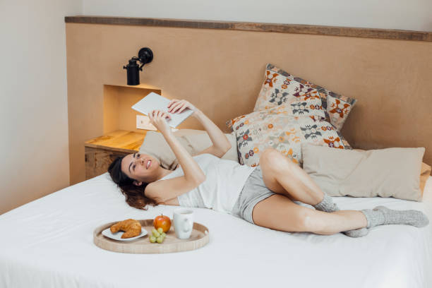 istock Woman with breakfast chilling on bed and using tablet 1459314619