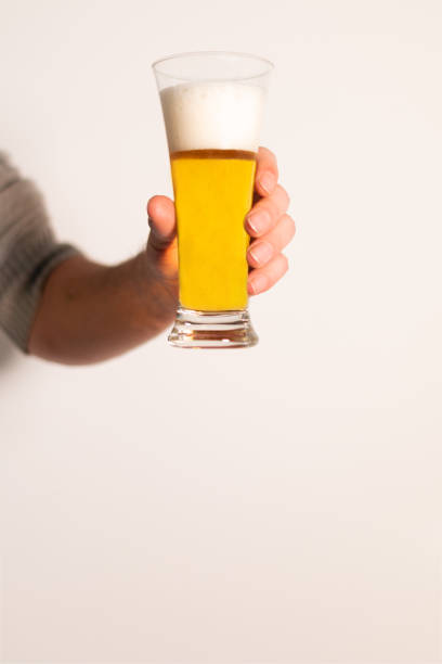 istock hand holding long glass of lager 1459316026