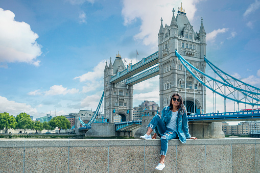 Asian women on a city trip in London by the river Thames at the famous places in London, Tower Bridge during summer