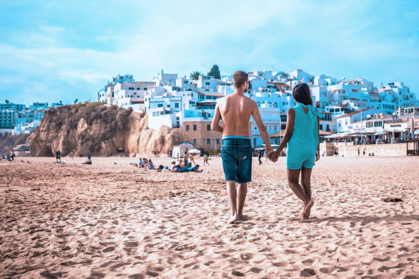 happy Young couple walking at the beach of Albufeira Algarve Portugal stock photo