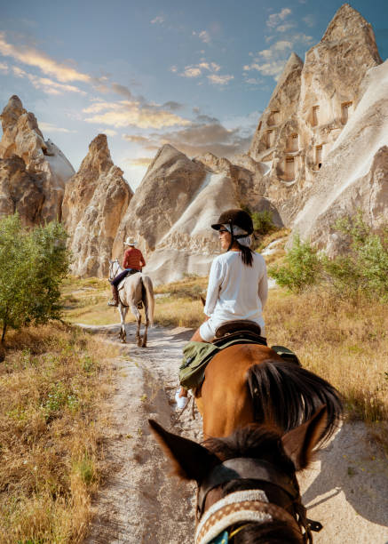 jeune femme à cheval pendant les vacances en turquie kapadokya regardant la cappadoce - goreme photos et images de collection