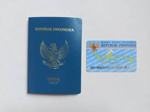 Indonesian passport and indonesian identity card. With indonesian text 'Republik indonesia' and 'kartu tanda penduduk'. It means Indonesia Republic and 'identity card'. Isolated background in white