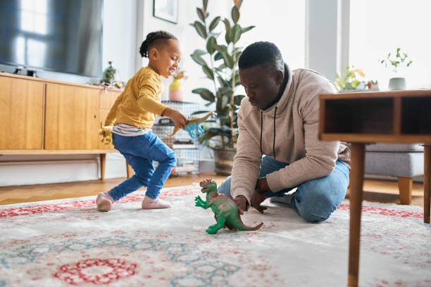 istock African man playing with smiling son at home 1459325796