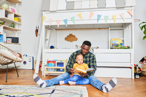 istock Father reading book to son at home 1459325953