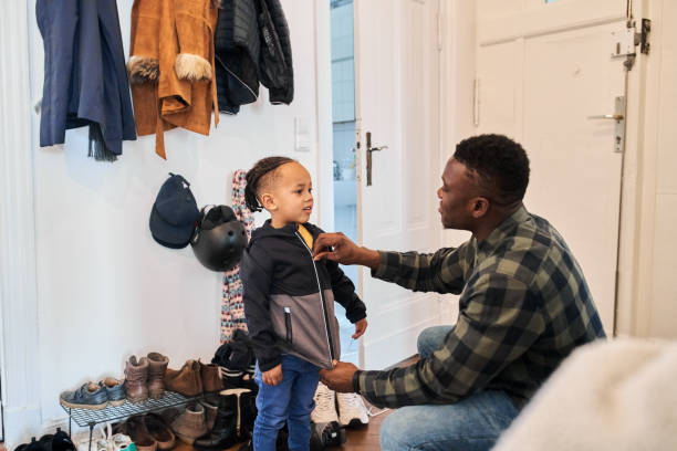 istock Boy getting dressed by father in mudroom 1459326296